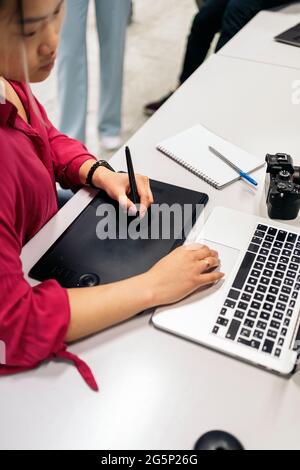 Asian female office worker sitting in her desk in the office and using her laptop. Stock Photo