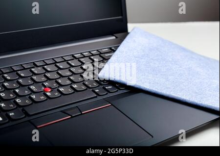 Laptop keyboard and cloth for cleaning surfaces. Disinfection new normal for cleaning workplace surfaces, office gadgets. Sanitize computer pc Stock Photo