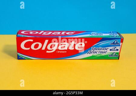Tyumen, Russia-June 21, 2021: Colgate Triple Action Extra Whitening toothpaste with calcium and fluoride. Multicolored background Stock Photo