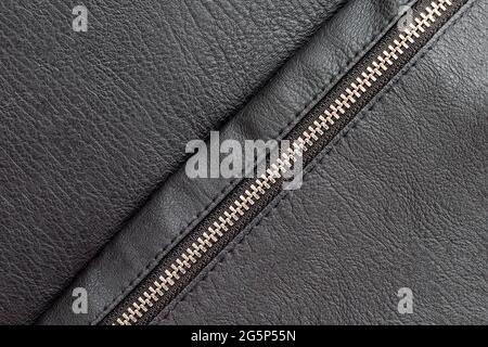 Black eco leather background with closed diagonal zipper. Stock Photo