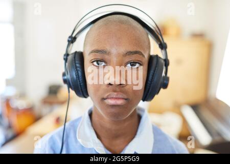 African schoolboy wearing headphones doing distance learning online as homeschooling Stock Photo