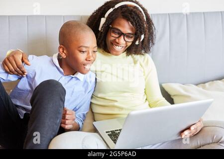 Son watches mother during video conference online on the sofa in the