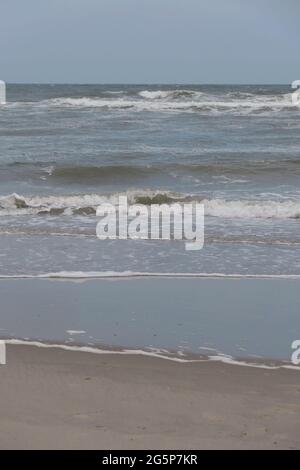 Waves breaking onto a sandy beach Stock Photo