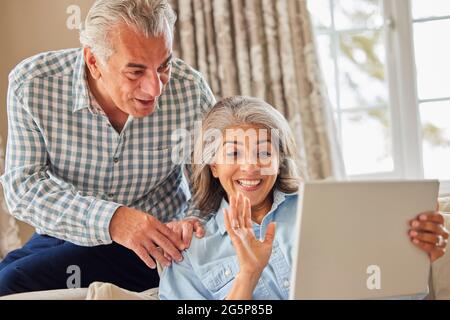 Mature Couple At Home Having Video Chat With Family Stock Photo