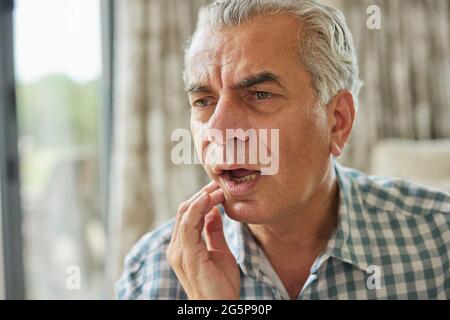 Mature Man At Home Suffering From Pain With Toothache Stock Photo