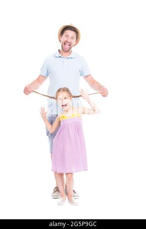 Vertical full length side view portrait of modern handsome Caucasian father spending time with his cute little daughter having fun together Stock Photo