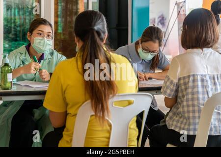 Chiang Mai, Thailand - 28 June 2021 - Thai nurses check people information before sending them in to get the COVID-19 vaccines in Chiang Mai, Thailand Stock Photo