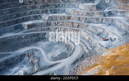 Open pit stone quarry aerial view with terraces and colorful tailings Stock Photo