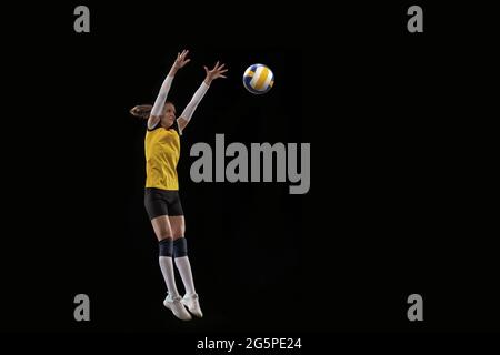 Female professional volleyball player with ball isolated on black studio background. The athlete, exercise, action, sport, healthy lifestyle, training Stock Photo