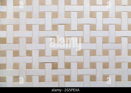 The texture of beige ceramic tiles with a weaving pattern. Construction material Stock Photo