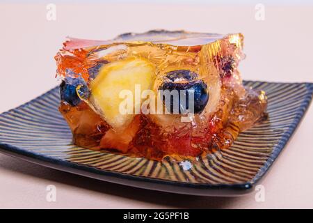 Jelly from different fruits and berries on a square saucer. Dessert. Close-up Stock Photo