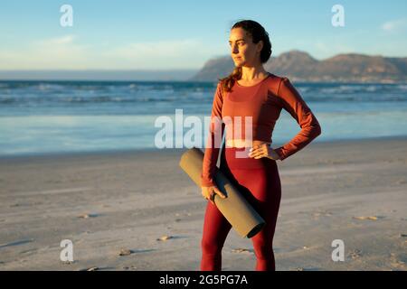 Portrait of caucasian women practicing yoga,standing at the beach and taking break Stock Photo