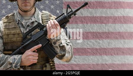 Composition of male soldier holding gun, against concrete wall with ...