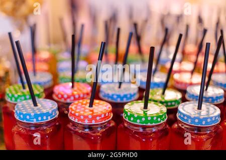 Juicy red smoothies in mugs with colorful polka dot lids. Proper nutrition. Freshness and pleasure. Retail trade. Delicious and healthy food. Lifestyl Stock Photo