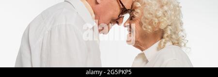elderly couple gently touching with heads isolated on white, banner Stock Photo