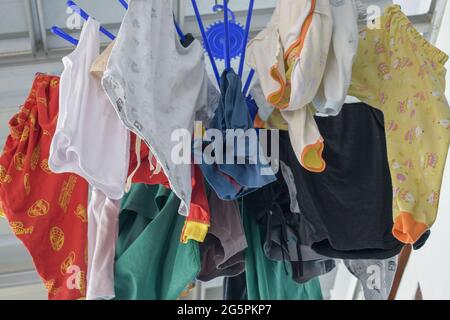 dry clothes. clothes that have been washed are dried in the sun to dry quickly and can be reused. the clothes hang on a blue hanger Stock Photo