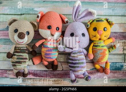 Crocheted teddy bear hare cat and chanterelle on a wooden background. Handmade toys. Stock Photo