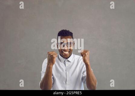Portrait of overjoyed african american man with clenched fist feeling excited Stock Photo