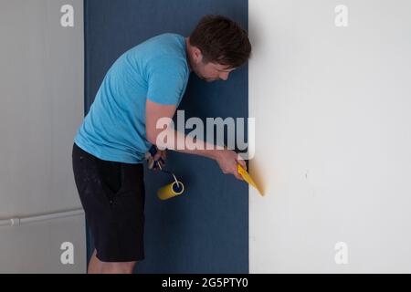 Closeup Photo Of Yellow Wallpaper Roller In Worker's Hand In White