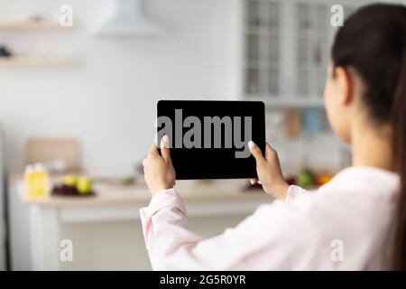 Lady using digital tablet with blank empty screen, mock up Stock Photo