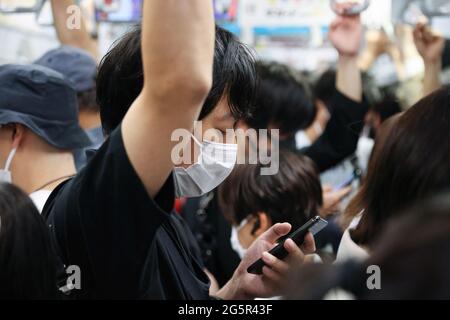 Tokyo, Japan. 28th June, 2021. Passenger wearing face masks as a precaution against the spread of covid-19 seen using their phones while in the subway train during the rush hours. (Photo by Stanislav Kogiku/SOPA Images/Sipa USA) Credit: Sipa USA/Ģ����ý Live News Stock Photo