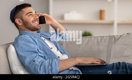 Smiling jew man working and talking on phone at home Stock Photo