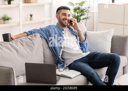 Smiling jew man working and talking on cellphone at home Stock Photo
