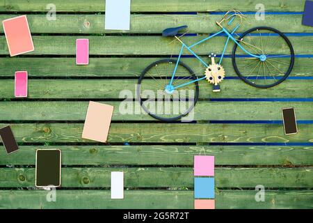 Decorative vintage blue bicycle and blank colorful frames hanging on the wooden planks of a fence. Stock Photo