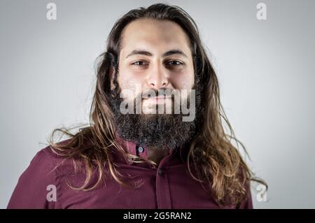 Middle east man with beard standing over blue background hugging ...