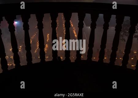 Thousands of Hindu devotees sits with candle (Prodip) for praying to God in front of Shri Shri Lokanath Brahmachari Ashram temple during the religious Stock Photo