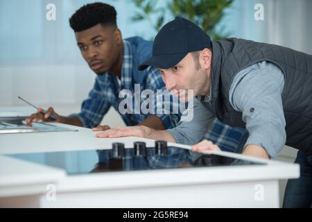 two men fitting a new kitchen Stock Photo