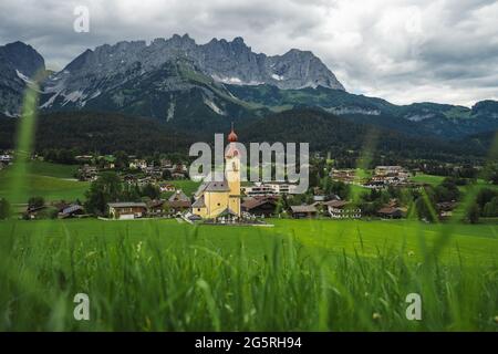 Yellow local church in Ellmau. Village of Going. Wilden Kaiser mountains in background. Tirol, Alps, Austria Stock Photo