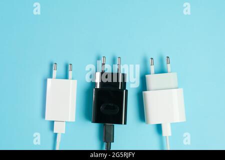 Power plugs with USB A and USB type C connectors from smartphone charger on the blue background with copy space.  Stock Photo