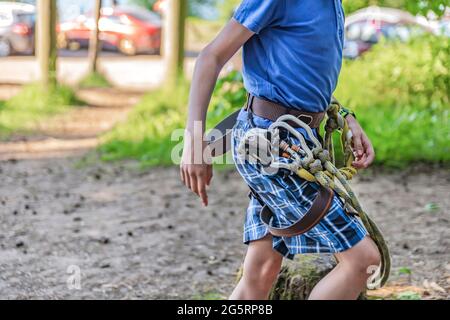 Forest Adventure Park. A child with special equipment overcomes obstacles in the forest adventure park. Banner for advertising and place to insert Stock Photo