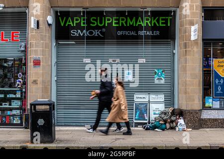 Manchester, Greater Manchester, UK. 20th Mar, 2021. Two shoppers walk past a sleeping homeless man.In the Shadow of Manchester's Beethan Tower, a tent sits there as a stark reminder of Manchester's extreme homeless epidemic. Andy Burnham promised in his 2017 election campaign to rid the city of homelessness but the pandemic has exacerbated the situation. Credit: Ryan Jenkinson/SOPA Images/ZUMA Wire/Alamy Live News Stock Photo