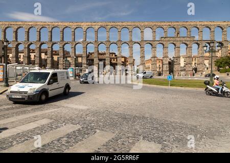 Segovia, Spain - June 2, 2021: General view of the Aqueduct of Segovia, on a sunny day, and the roundabout for traffic next to Plaza del Azoguejo Stock Photo