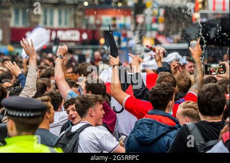 London, UK. 29th June, 2021. Fans gather in Leicester Square after Englands victory in the UEFA Euro 2020 v Germany. The police just observe and monitor the situation. Credit: Guy Bell/Alamy Live News