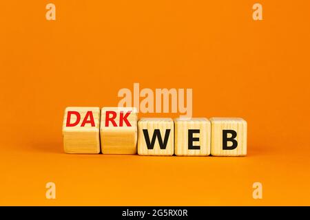 Dark web symbol. Turned wooden cubes and changed the word web to dark web. Beautiful orange background. Business, dark web concept. Copy space. Stock Photo