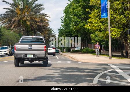 Gainesville, USA - April 27, 2018: Road street cars in downtown Florida city with University of Florida UF campus with students walking on sidewalk Stock Photo