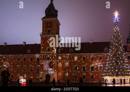 Warsaw, Poland - December 19, 2019: Old town square at night with Christmas illumination decoration tree lights on royal square and people at famous l Stock Photo