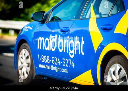 Herndon, USA - May 27, 2021: Northern Virginia Fairfax county with maid bright van for home cleaning residential service with blue yellow logo on car Stock Photo