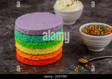 Cake assembly. layer cake with white icing and sprinkles. Stock Photo
