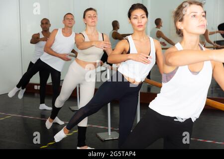 Ballet dancers practicing at barre in dance class Stock Photo