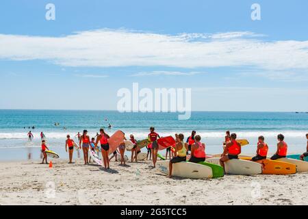 Mount Maunganui New Zealand -January 20 2015; Surf club members wait with their boards by water's edge Stock Photo