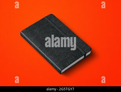 black closed notebook mockup isolated on red Stock Photo