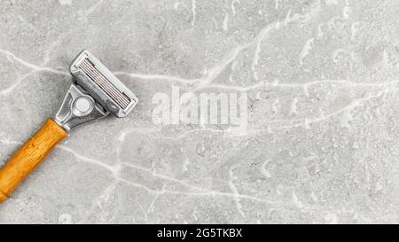 Wet shaving Razor with five blades head and wooden handle on a grey marble background. Copy Space for text Stock Photo