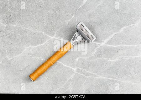 Shaving Razor with wooden handle on a grey marble background. Plastic free hygiene tool Stock Photo