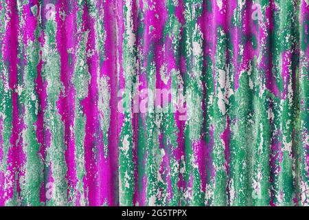 colorful motley peeled off green and pink paint layers on corrugated zinc coated steel sheet - full frame background and texture Stock Photo