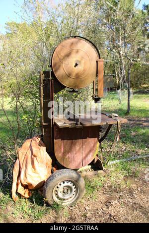 Old rusted band saw with wheels Stock Photo