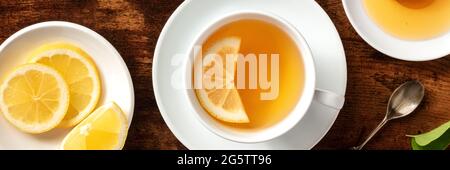 Lemon tea with honey panorama. Healthy and tasty organic citrus detox beverage, shot from the top on a rustic wooden table Stock Photo